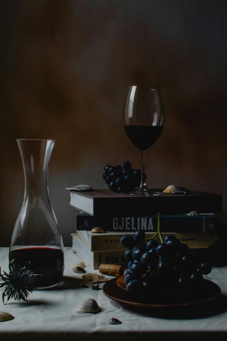 Notre cave Sophisticated still life featuring red wine, glass, and grapes with beautiful dark tones.